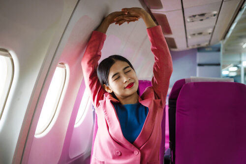 Woman stretching in plane seat