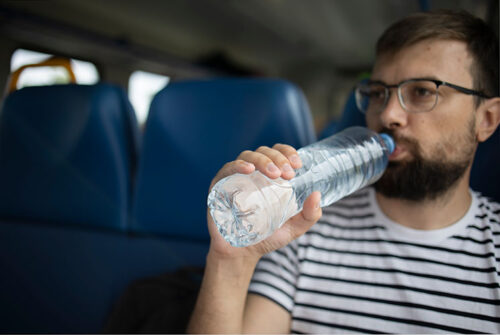 Man hydrating on plane