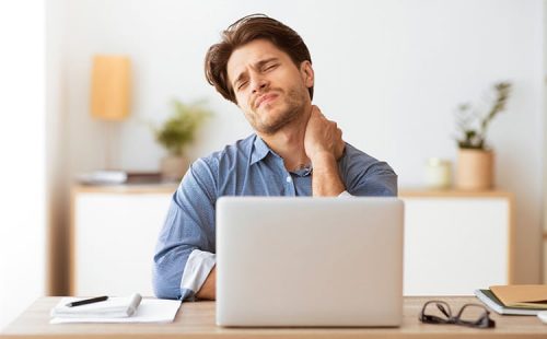 Man at computer experiencing neck pain