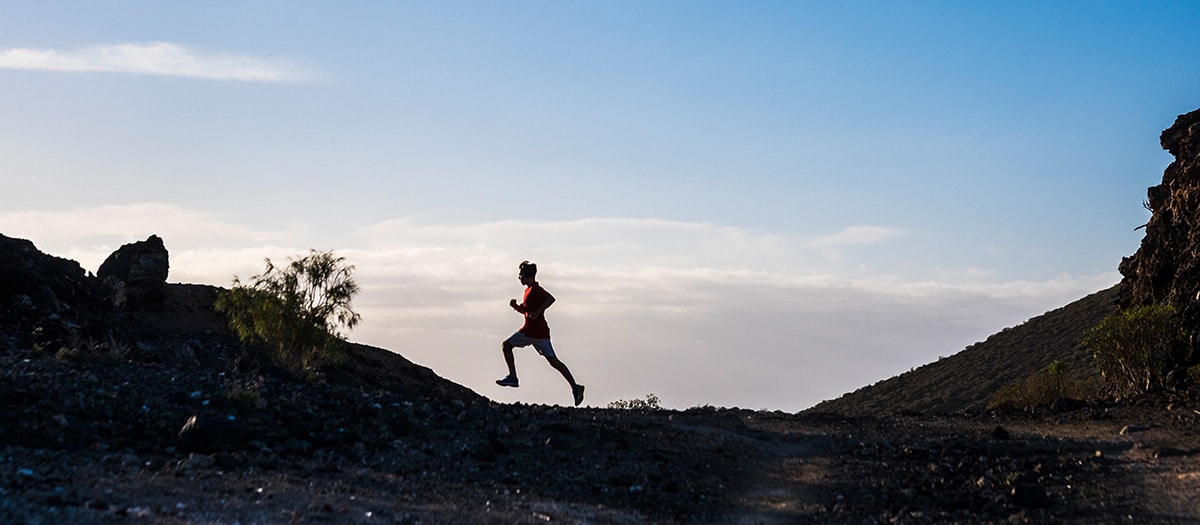 Runner on mountain trail in desert