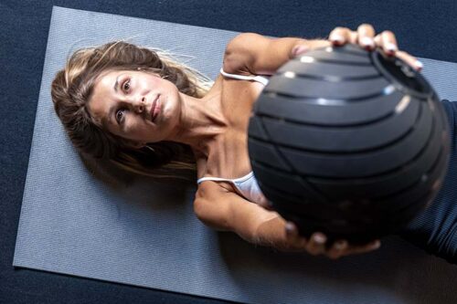 Hypermobile woman doing medicine ball exercise