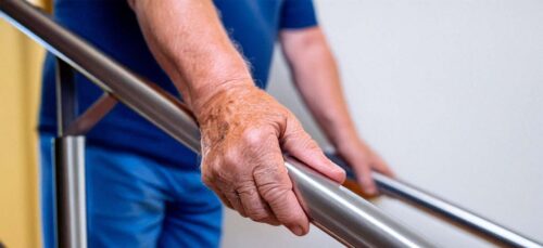 Close-up of man gripping handrail on stairs