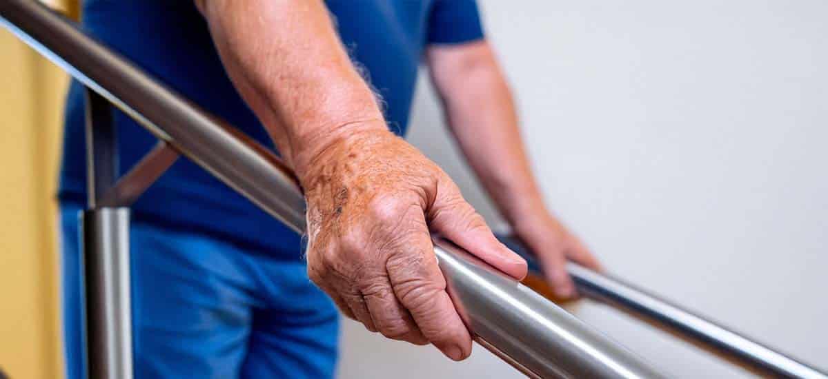 Close-up of man gripping handrail on stairs