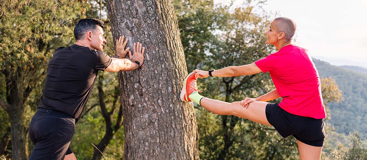 Photo of couple stretching before going on a run in nature