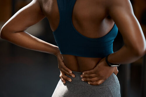 Woman with back pain standing and taking a break